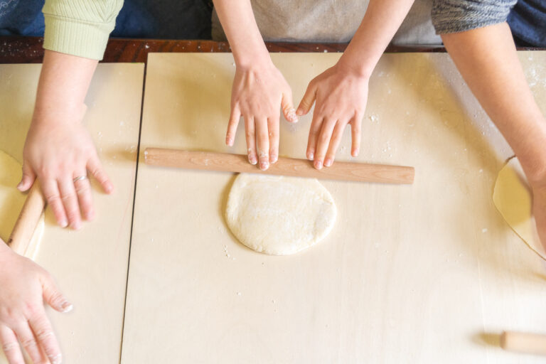 Rolling ramen dough thin with a rolling pin